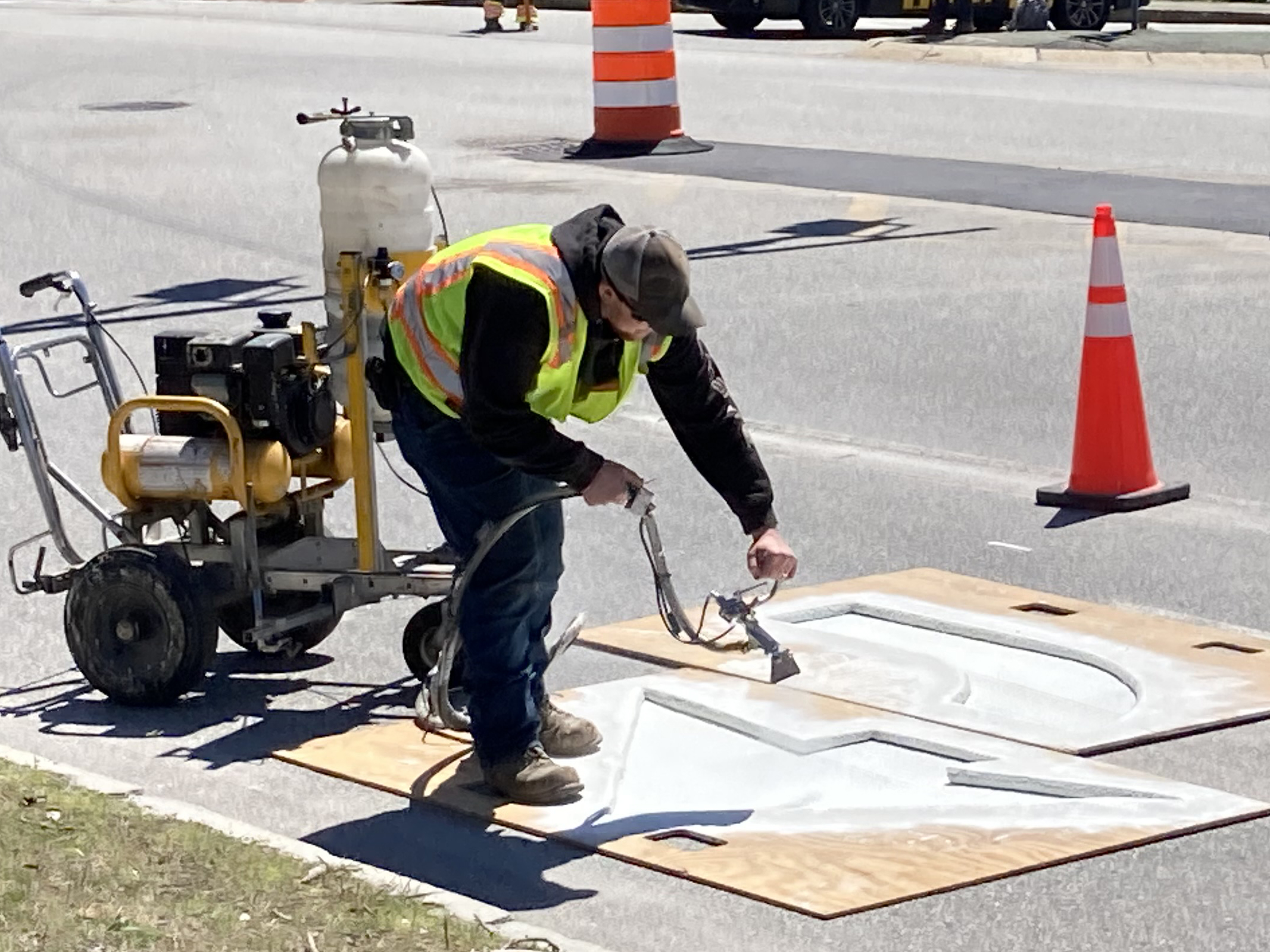 Wokers paint temporary pavement markings onto road